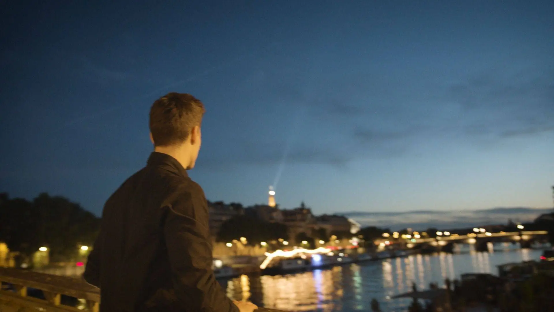 young videographer looking at the horizon in Paris evening